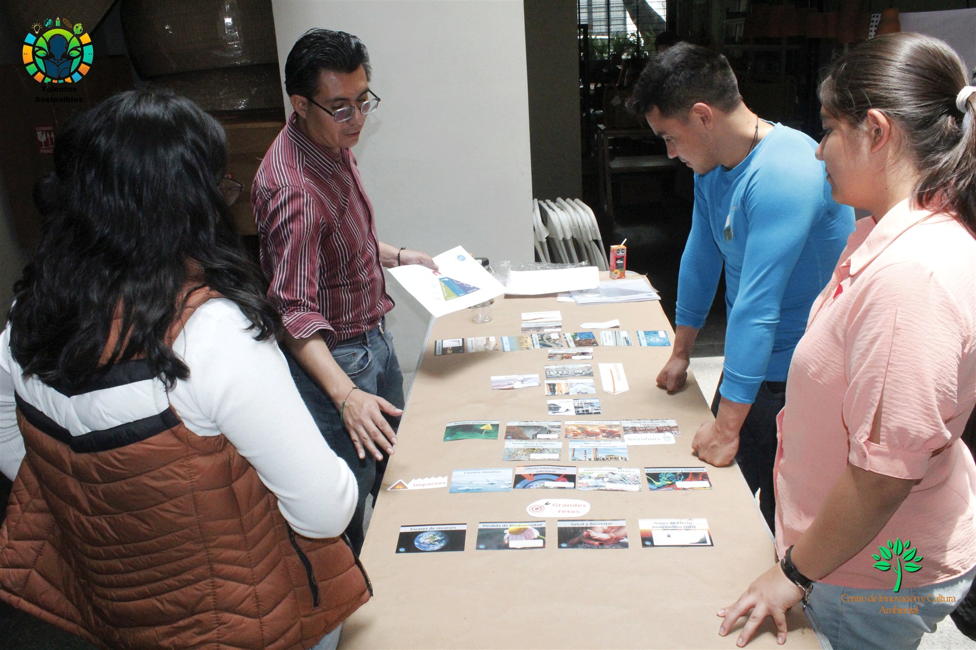 Participantes analizan tarjetas alrededor de una mesa durante el Mural de la Economía Circular