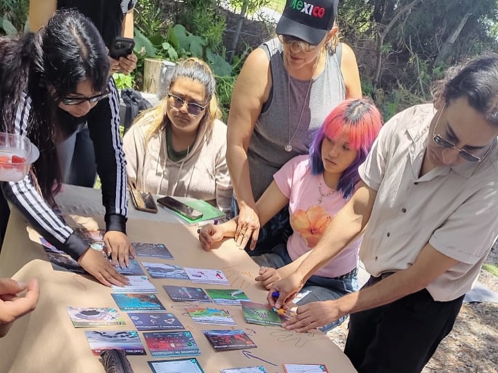 Participantes construyen el Mural del Clima con cartas durante una actividad grupal